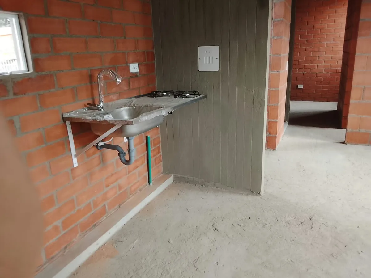 Cocina con lavaplatos en acero inoxidable y estufa a gas de cuatro puestos