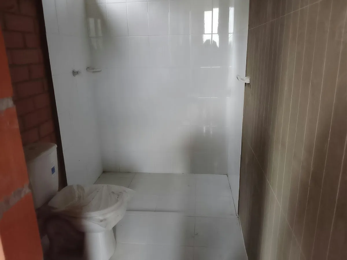 Baño enchapado con sanitario y ducha